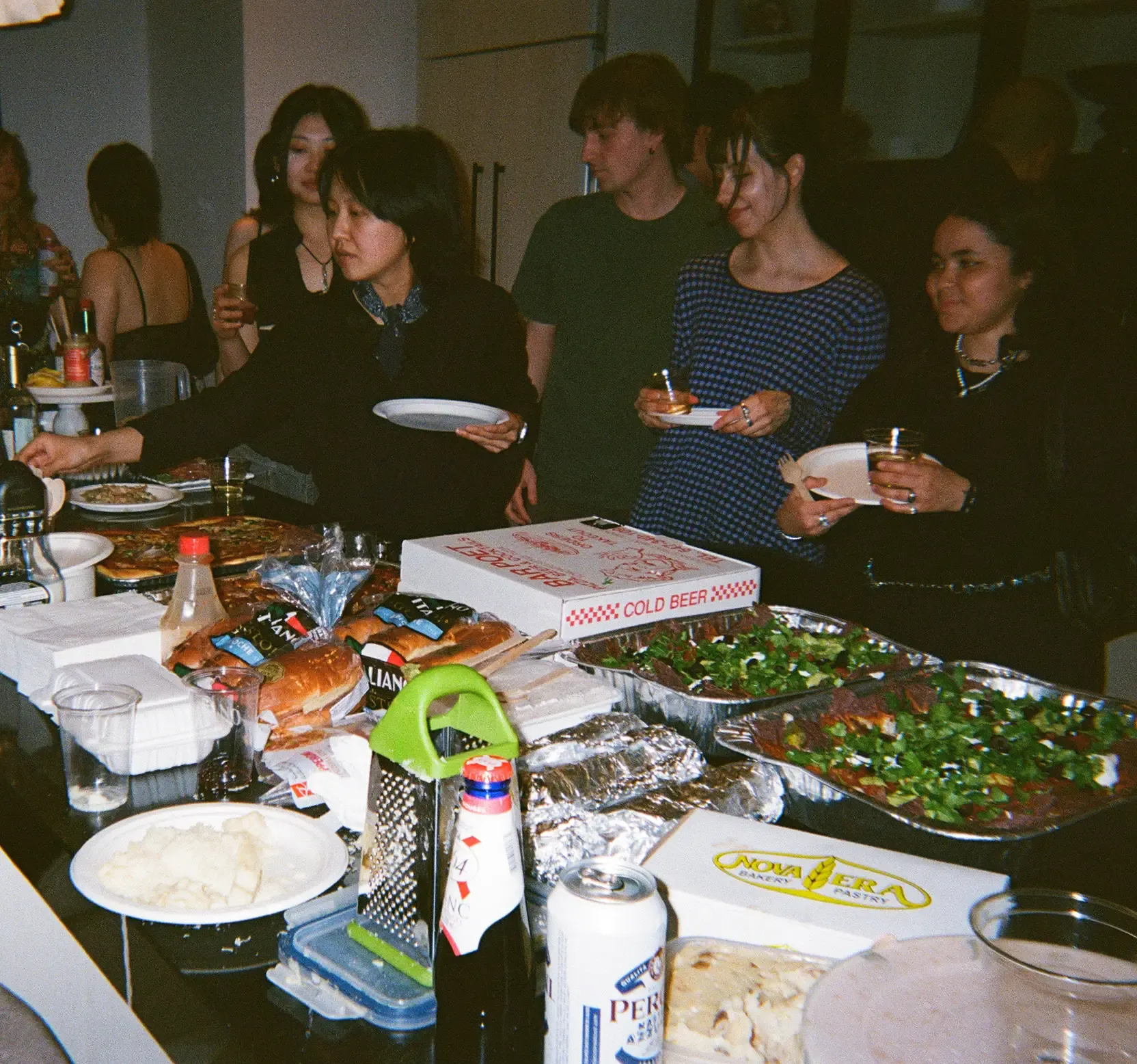 Mid shot of Fond dinner party setup with guests line up to fill their plates with food